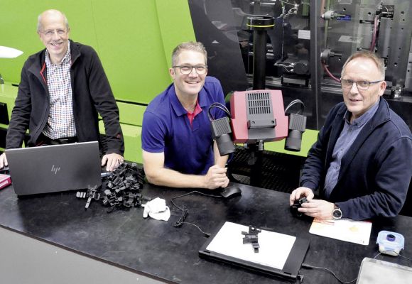 Franz Bokop und Wilfried Hinxlage mit Volker Platen vor einer Maschine für Kunststoffbauteile