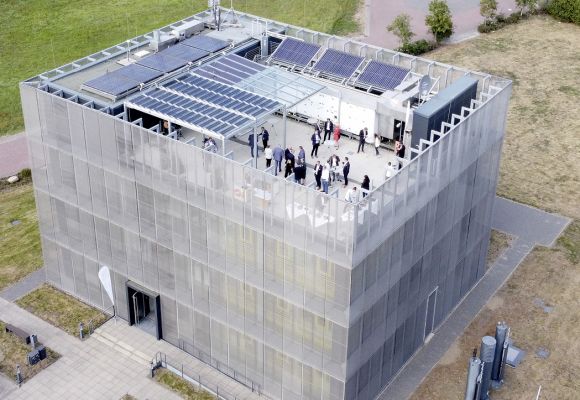 Luftbild eines Gebäudes mit Personen auf der Dachterrasse