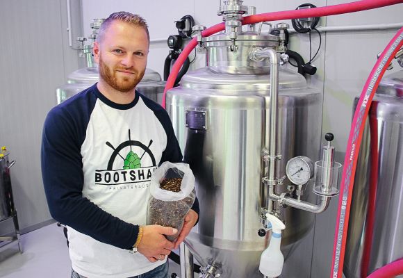 Bootshaus-Brauerei-Chef Christopher Franz mit Gerstenmalz in seiner Brauerei.