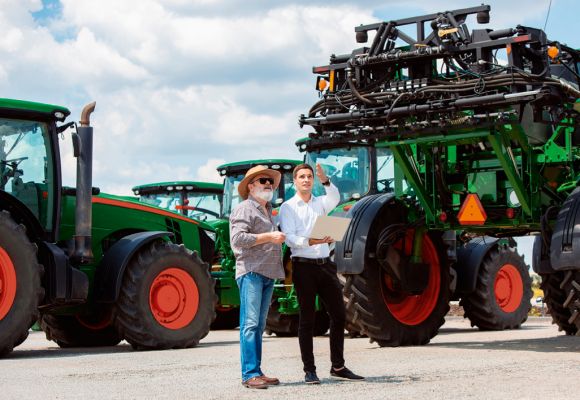 Zwei Personen vor landwirtschaftlichen Maschinen